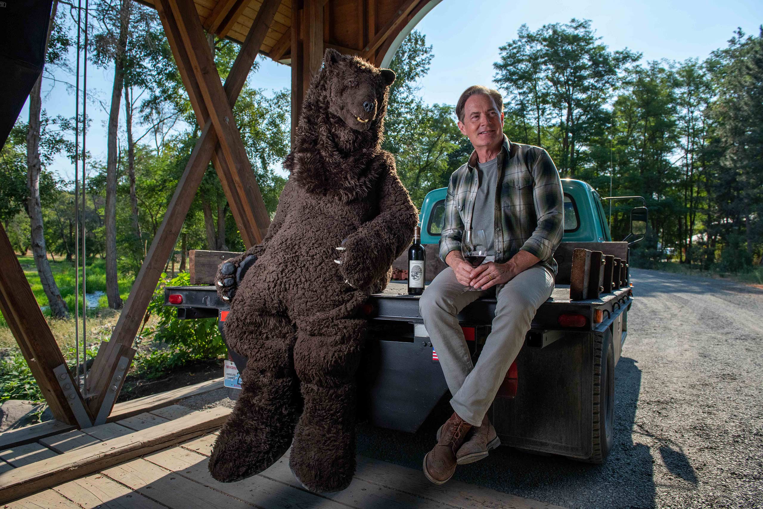 Kyle and Bear sitting in a truck enjoying a glass of wine