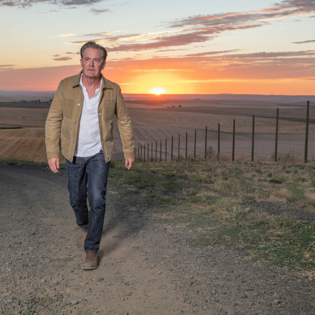 Kyle walking up a country road at sunset