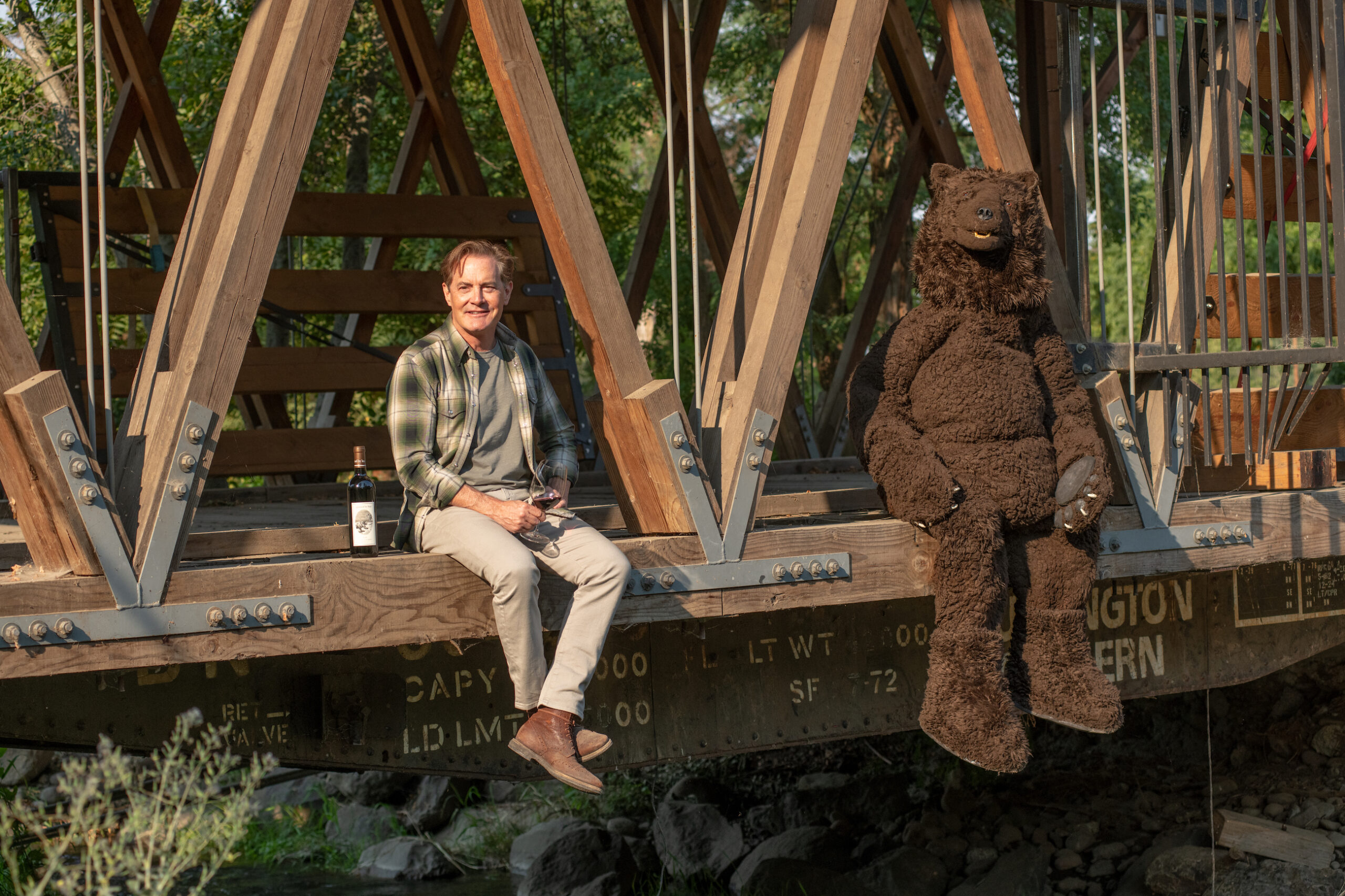 Kyle and Bear sitting on a bridge together
