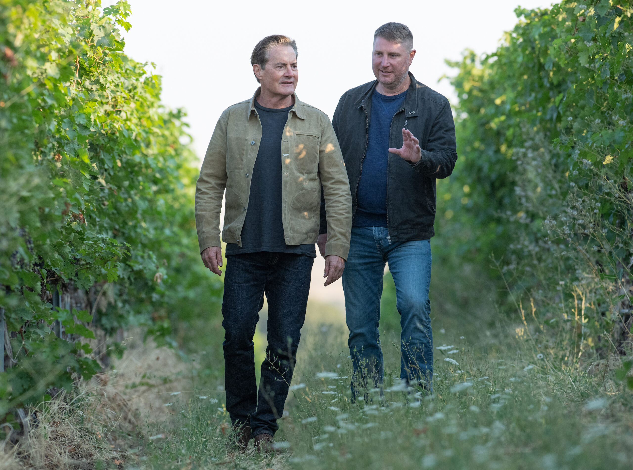 Kyle and Dan walking and talking in the vineyard