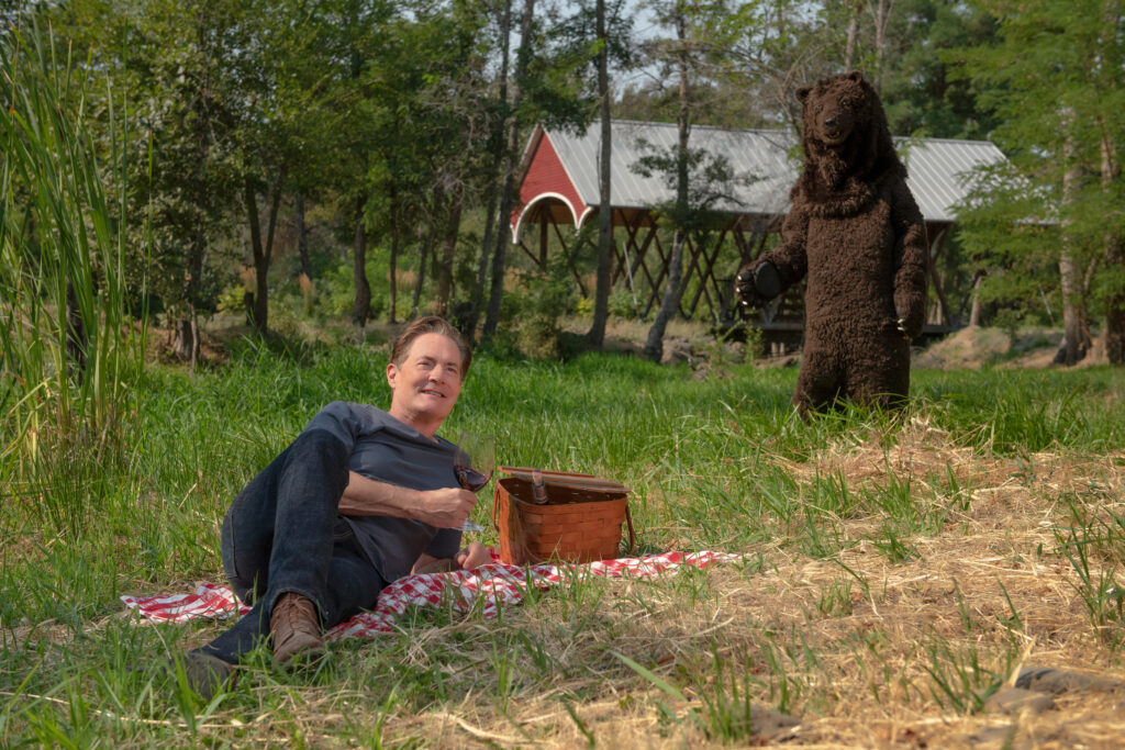 Kyle picnicking with Bear in background