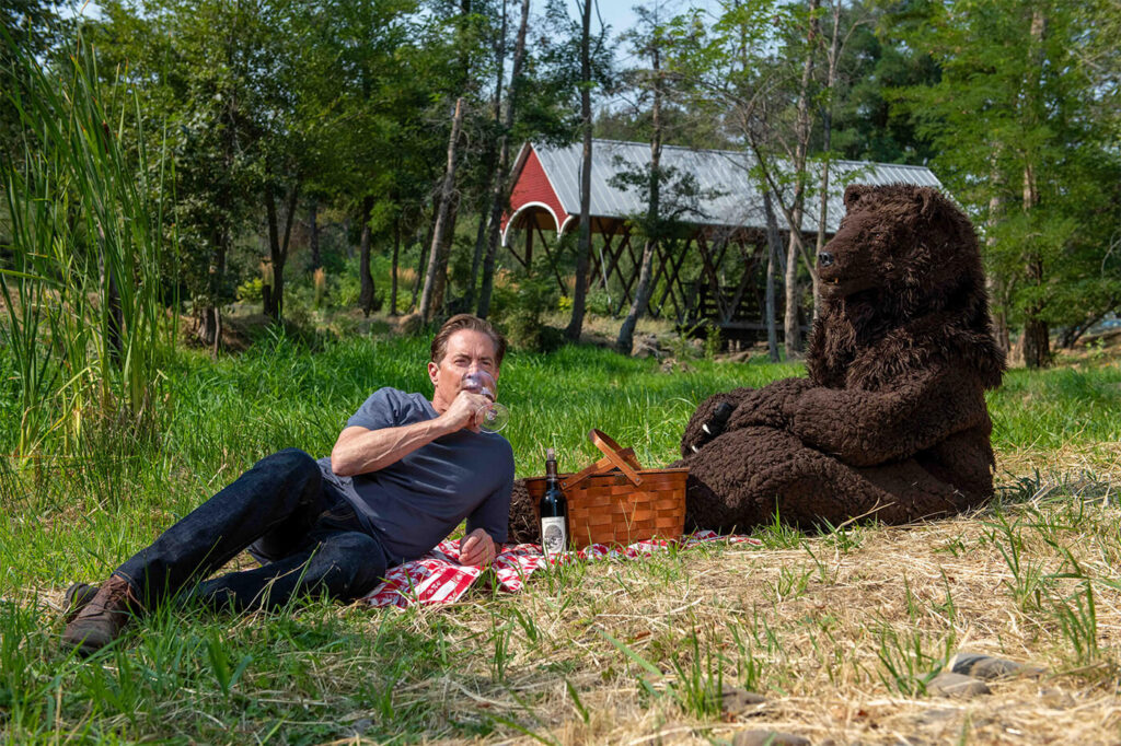 Kyle picnicking with Bear in background